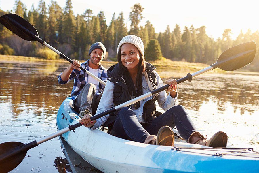 Employee Benefits - Couple Rowing in a Kayak On Lake in Michigan at Sunset